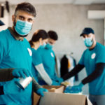 group people with protective face masks packing donation boxes food charity 676x451 111677
