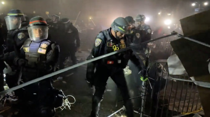Polícia začala rozoberať protestný stanový tábor na Kalifornskej univerzite v Los Angeles, demonštranti sa bránili dáždnikmi (video)