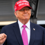 Donald Trump na podiu s cervenou siltovkou
