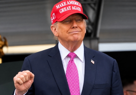 Donald Trump na podiu s cervenou siltovkou