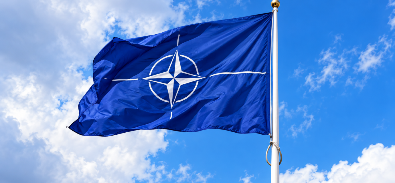 Vlajuca vlajka NATO na modrej oblohe