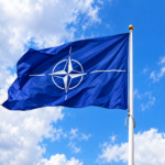 Vlajuca vlajka NATO na modrej oblohe