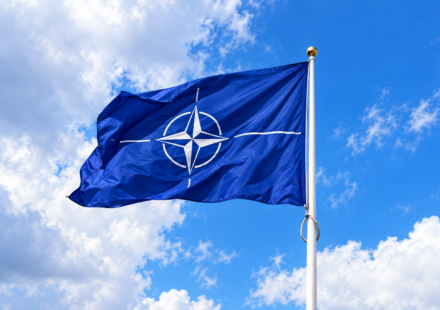 Vlajuca vlajka NATO na modrej oblohe