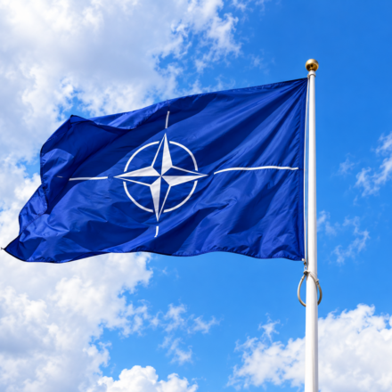 Vlajuca vlajka NATO na modrej oblohe