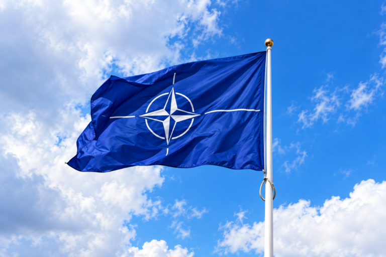 Vlajuca vlajka NATO na modrej oblohe