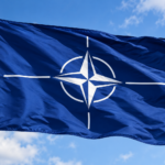 Vlajuca vlajka NATO pod modrou oblohou