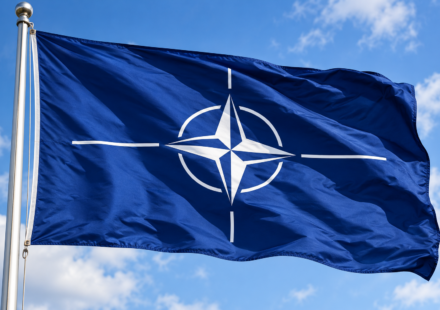 Vlajuca vlajka NATO pod modrou oblohou